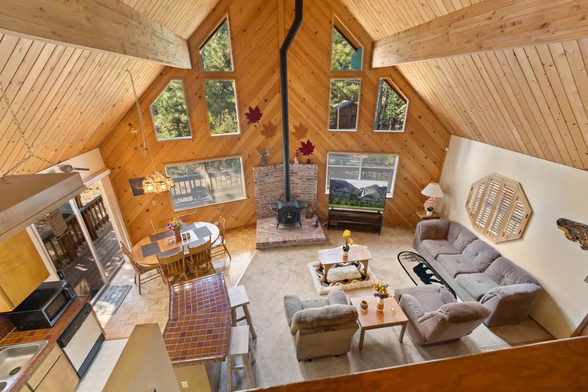 Living room with A-frame windows and a wood stove, Knotty Pine Chalet