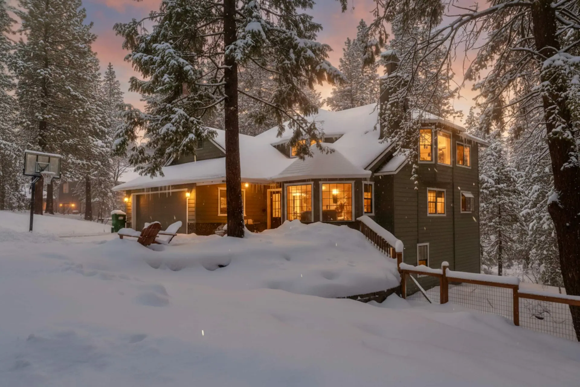 The house in deep snow at dusk, windows glowing, Twain Harte Retreat